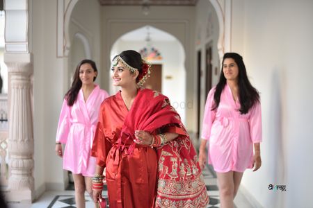 A bride posing with her coordinated bridesmaids in a robe 