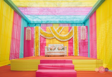 funky mehendi stage backdrop with loads of colours