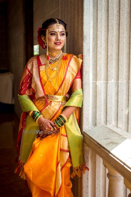 Photo of A Marathi bride in a yellow saree with red border