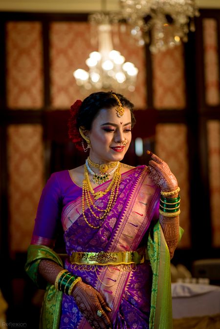 A Marathi bride in a purple saree with gold jewellery 