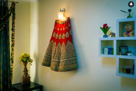 Photo of Red and Gold Bridal Lehenga on a Hanger Shot