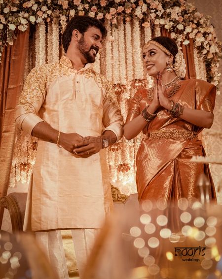 A south Indian couple in coordinated gold and creme outfits 