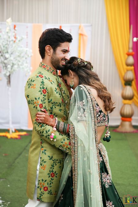 matching bride and groom in green outfits for their mehendi