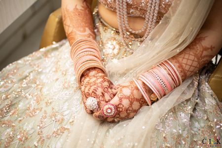 bridal hands with pastel outfit and cocktail rings on wedding