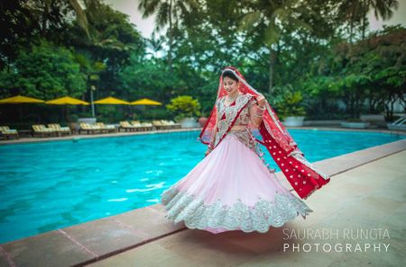 Photo of Twirling Baby Pink Lehenga with red Dupatta Shot