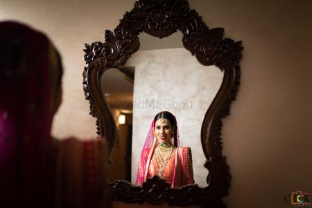 Photo of bride looking at mirror after getting ready on wedding day