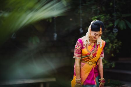 bride in hot pink and yellow kanjivaram saree on her wedding day