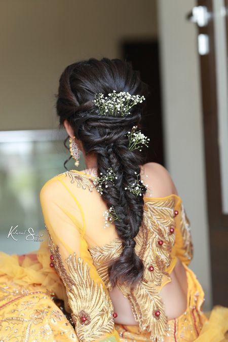 A bride flaunting her braided hair with baby breath