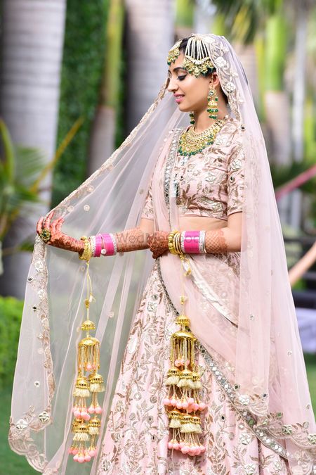 Photo of Bride in light pink lehenga with matching kaleere