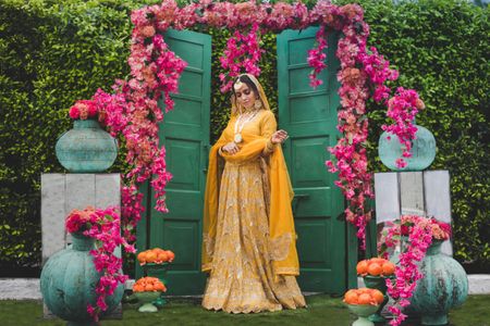 Photo of bride in yellow posing against cool door decor