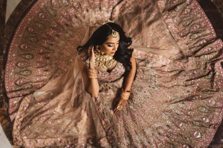 Photo of bride to be sitting with onion pink flared lehenga