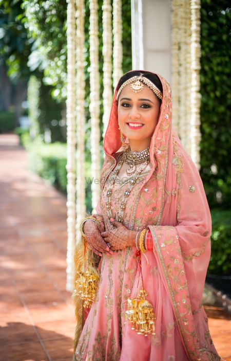 Photo of Pastel Pink Sikh Bride with Gold Kaleere
