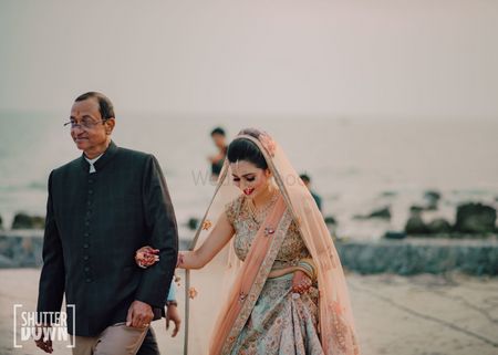 bride entering her wedding with her father 