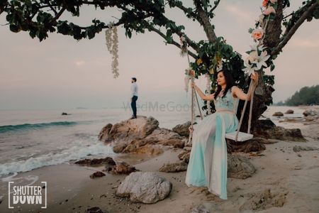 beach pre wedding or honeymoon shot with bride on swing