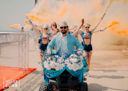 Photo of groom entering on atv with people holding smoke sticks