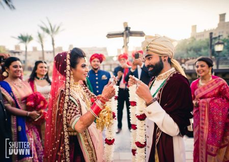 coordinated bride and groom jaimala shot in maroon 