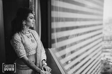 Photo of bride looking out of window shot in black and white