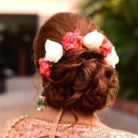 Photo of A bridal bun with flowers.