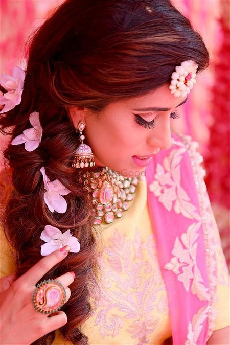 bridal mehendi look with side braid with flowers and floral jewellery