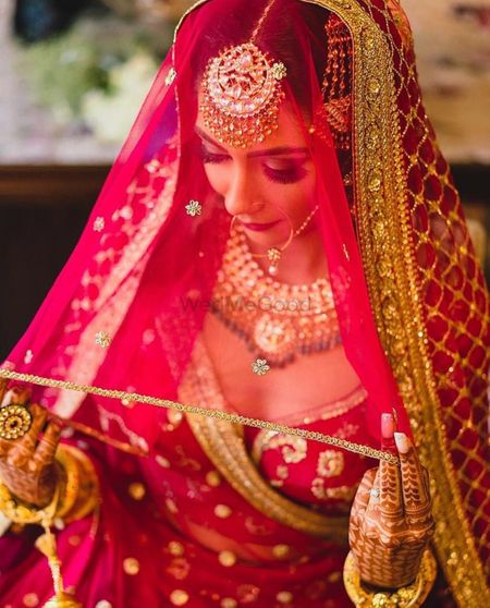 Photo of bride holding her sabyasachi dupatta as a veil