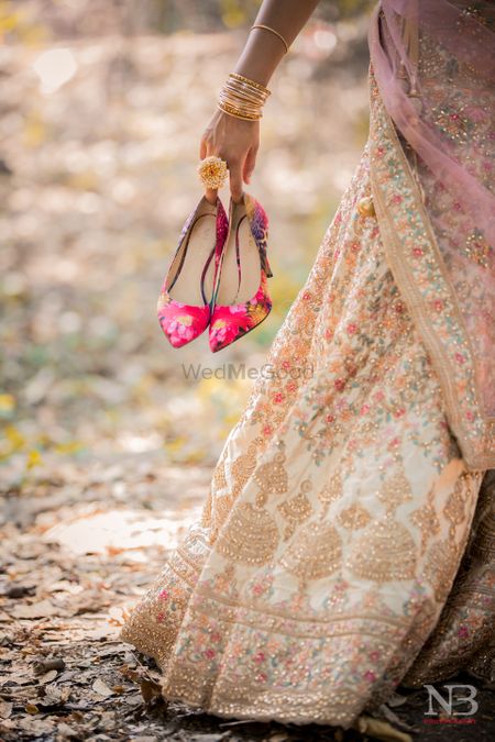 Photo of bride holding her hot pink bridal shoes