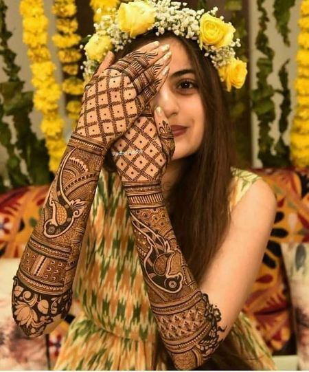 Bride with intricate back hand mehndi design. 