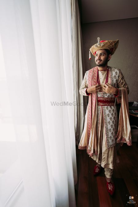 Groom in an off-white embroidered sherwani.