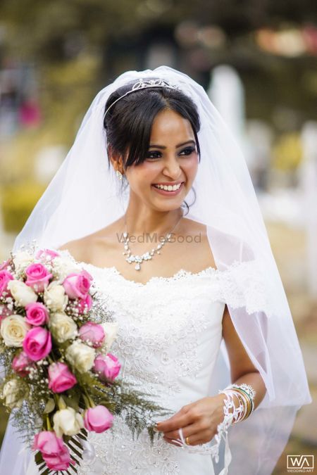 Photo of A happy bride holding a beautiful bouquet.