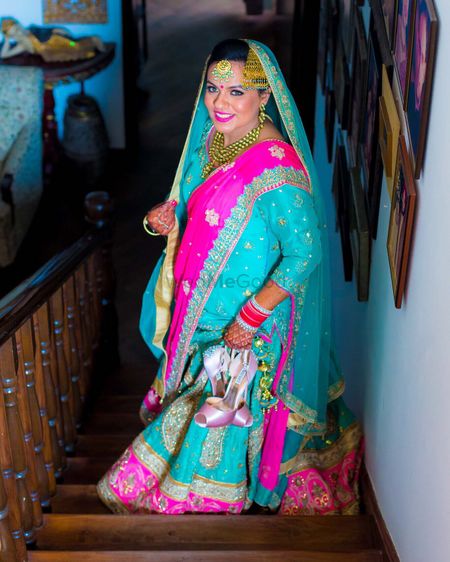 Photo of Turquoise Blue and Fuchsia Bride Carrying Heels