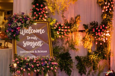 A pretty entrance decked with flowers and a welcome sign in muted shades. 