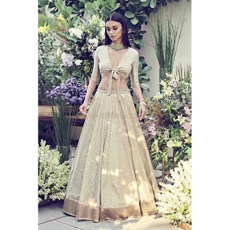 Photo of unique engagement lehenga in beige with tie up blouse