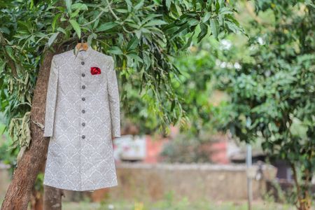 White Sherwani with Red Pocket Square on a Hanger
