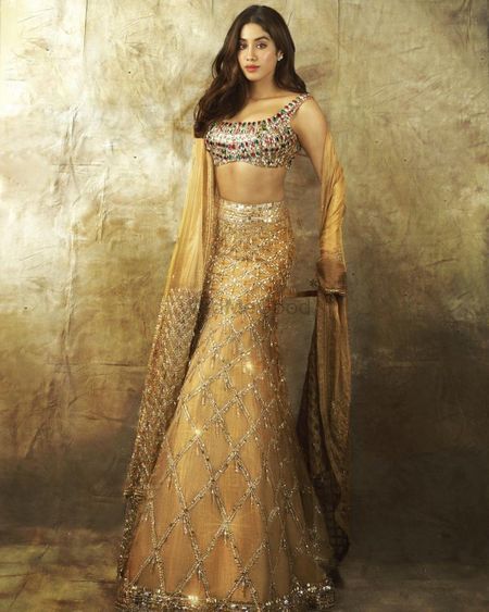 Heavily embellished multistones blouse with golden lehenga. 