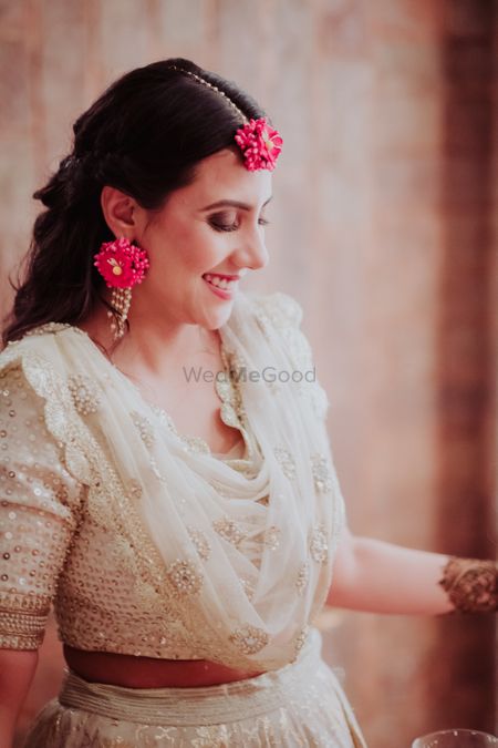 A bride in white sequined lehenga with contrasting floral jewellery