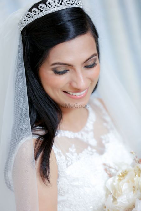 Real bride wearing white wedding gown with soft, smokey eyes and nude lips