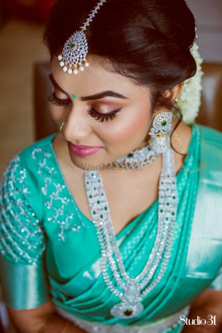 A portrait of a bride dressed in turquoise saree