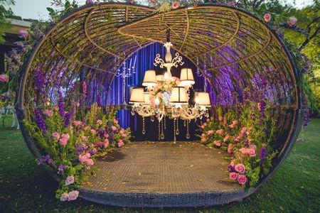 A unique photobooth setup with floral arrangements and a chandelier