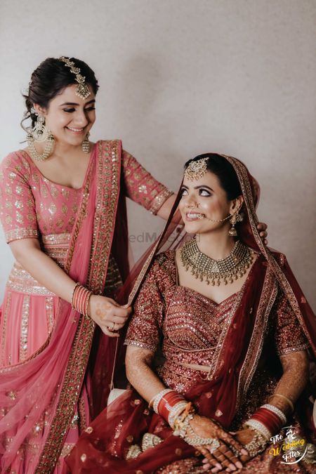 Sister helping the bride with dupatta. 