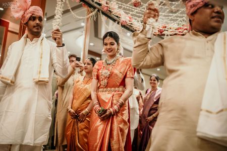 A South Indian bride making an entry under a phoolon ki chaadar.