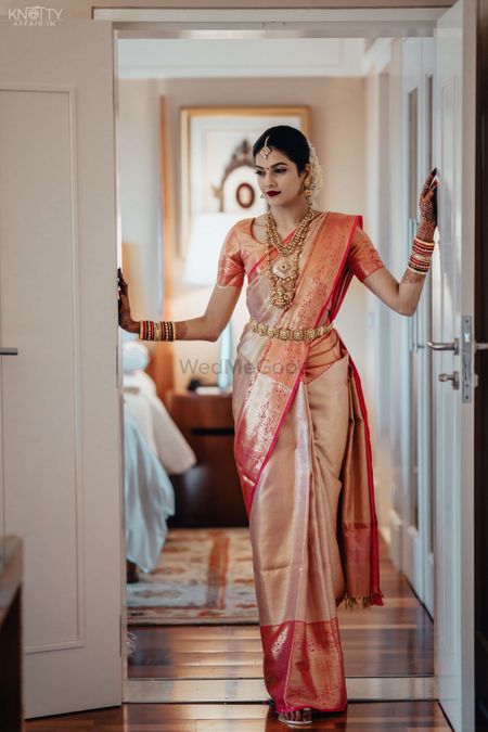 A candid shot of a bride dressed in her wedding saree