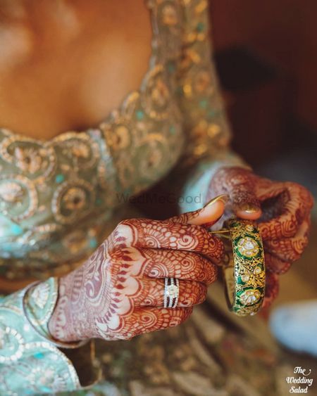Photo of A stunning getting ready shot of a bride fixing her jewellery.