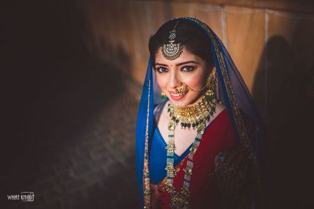 Bride dressed in a blue lehenga with a red dupatta