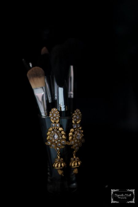 Gold Kundan Earrings Hanging on a Makeup Kit