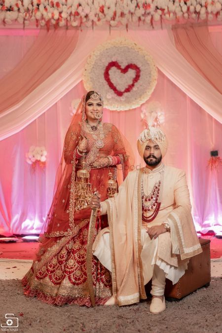 A royal sikh couple posing on their wedding day.