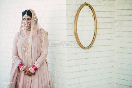 Bride in Pastel Pink Lehenga and Red and White Chooda