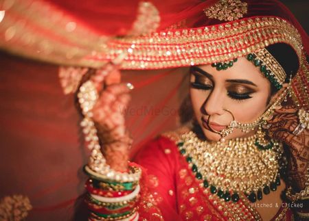 A beautiful bridal shot on her wedding day in gold jewellery with subtle makeup . 