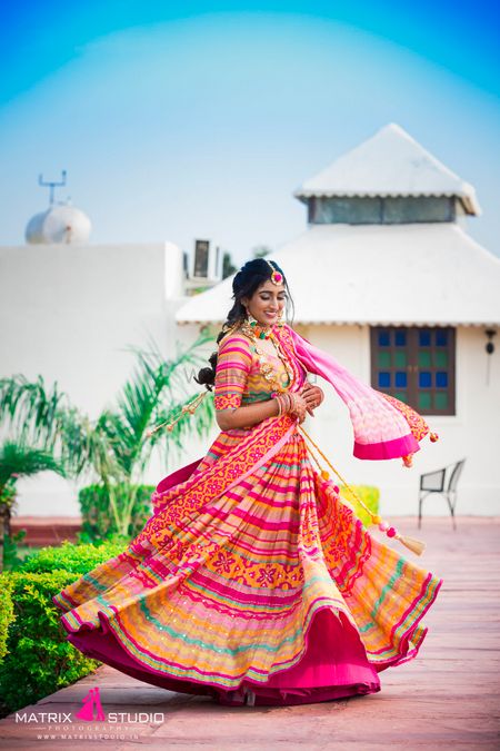 A twirling lehenga shot of the bride in a bright pink lehenga 