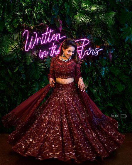 Photo of The bride twirls in a gorgeous maroon lehenga on her sangeet