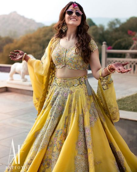 A twirling shot of the bride in a bright yellow lehenga 