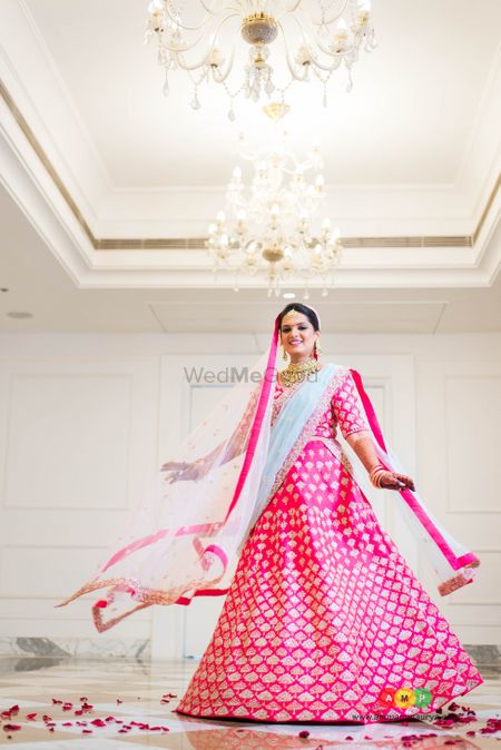 Twirling bride in bright  pink lehenga